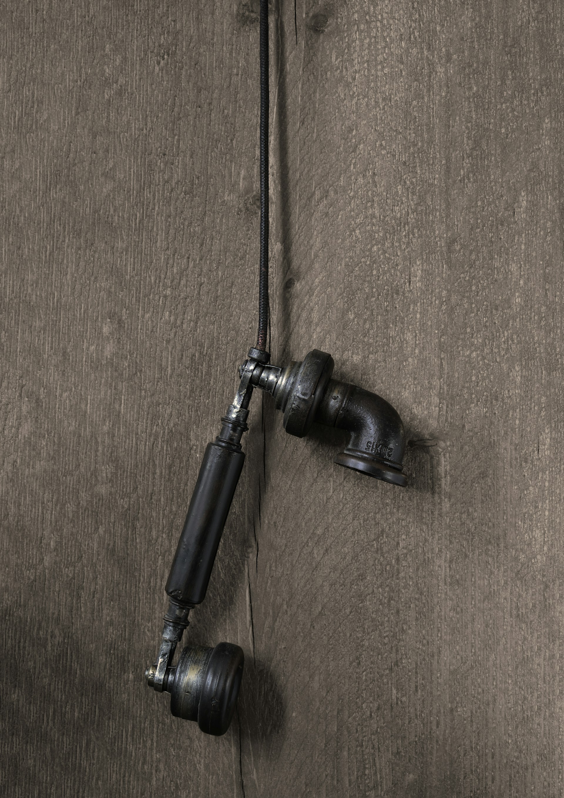 a pair of black hoses attached to a wooden wall