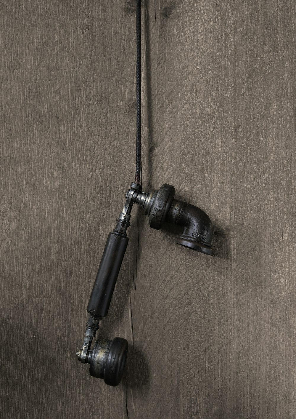 a pair of black hoses attached to a wooden wall