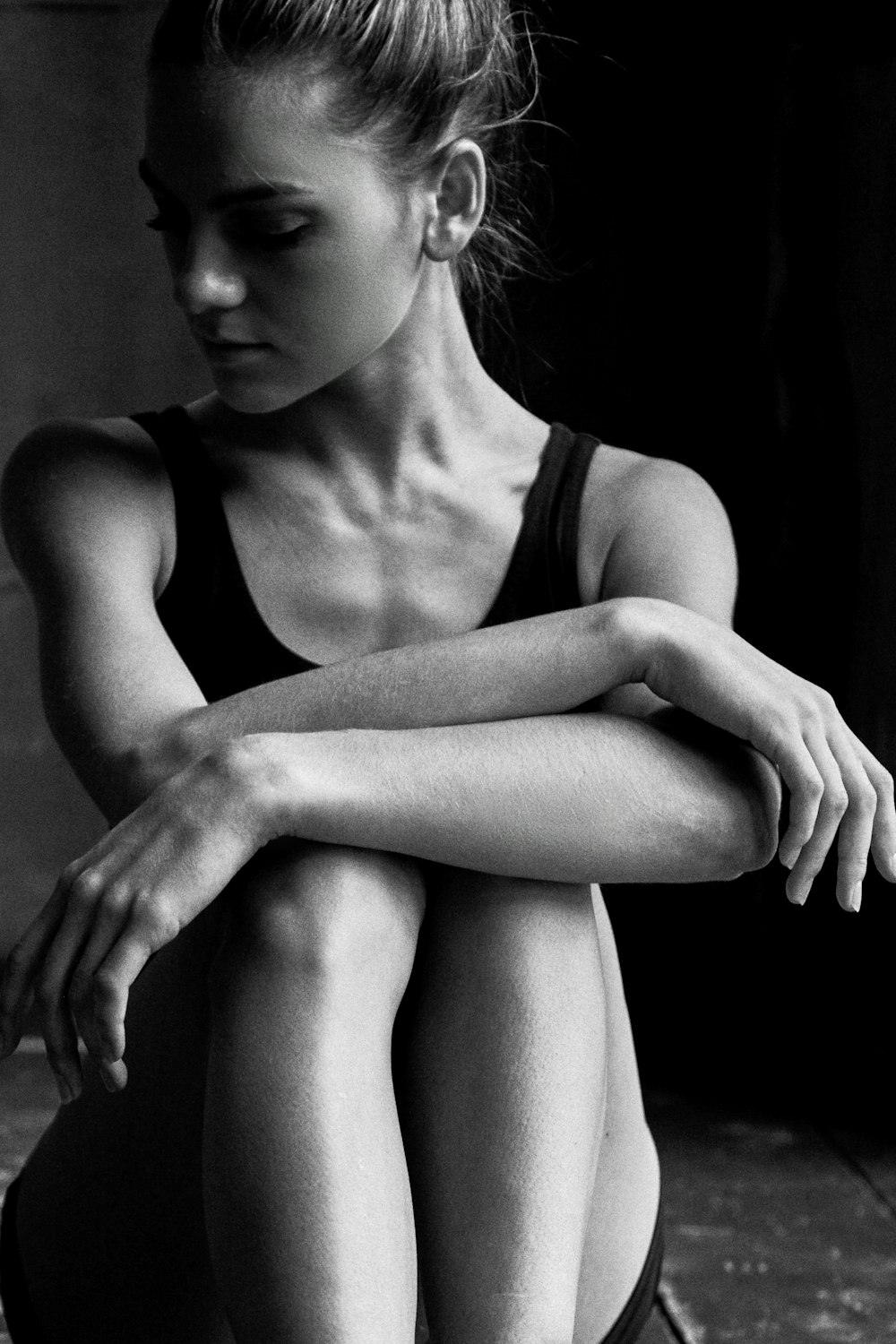 a black and white photo of a woman sitting on the ground