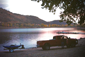 Oldft36's converted fire truck parked beside a serene lake at sunset