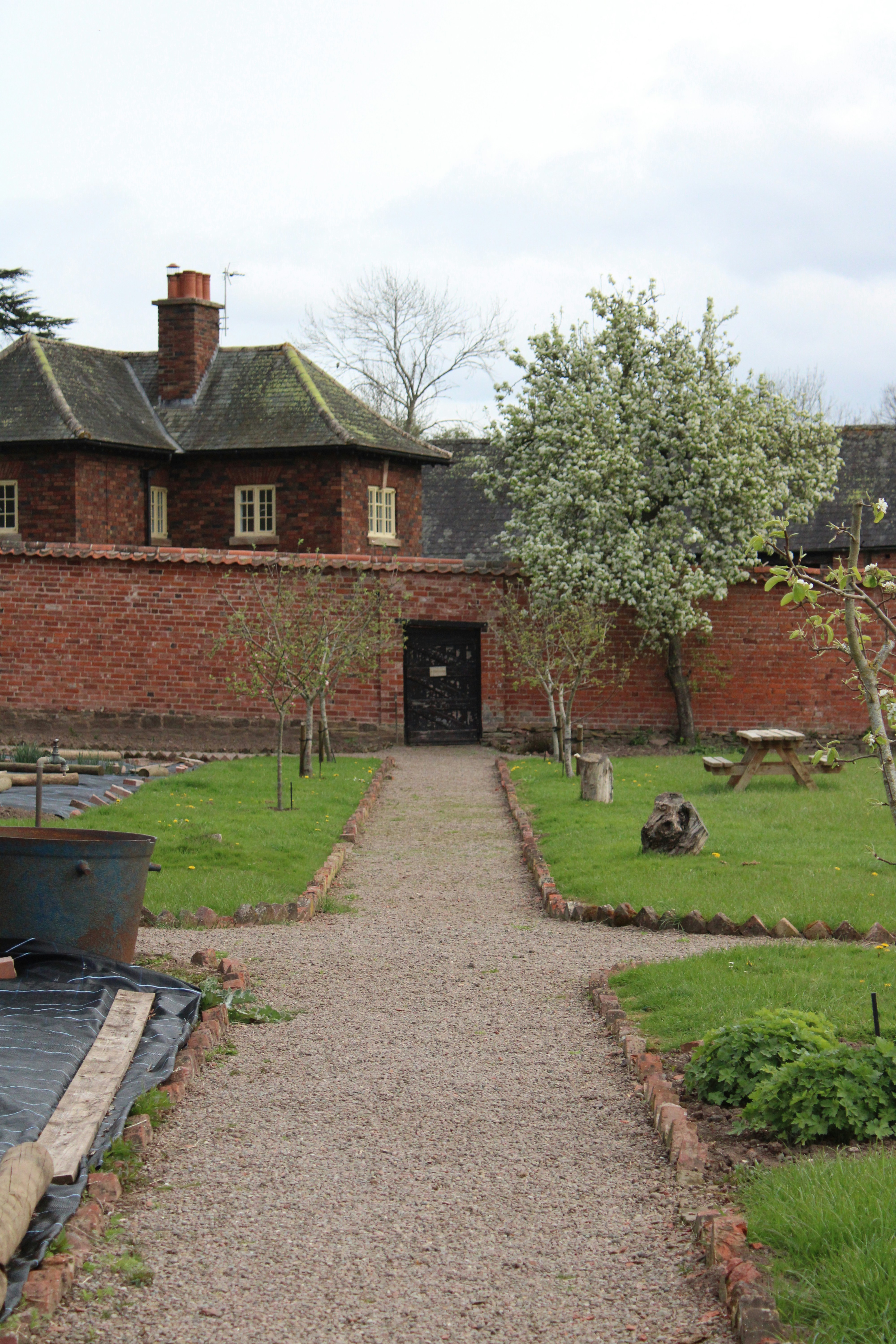 手前にボートがあるレンガ造りの建物に通じる小道