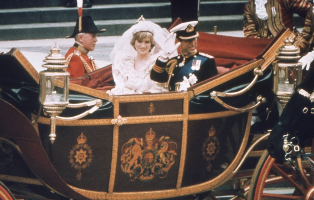 a bride and groom riding in a horse drawn carriage