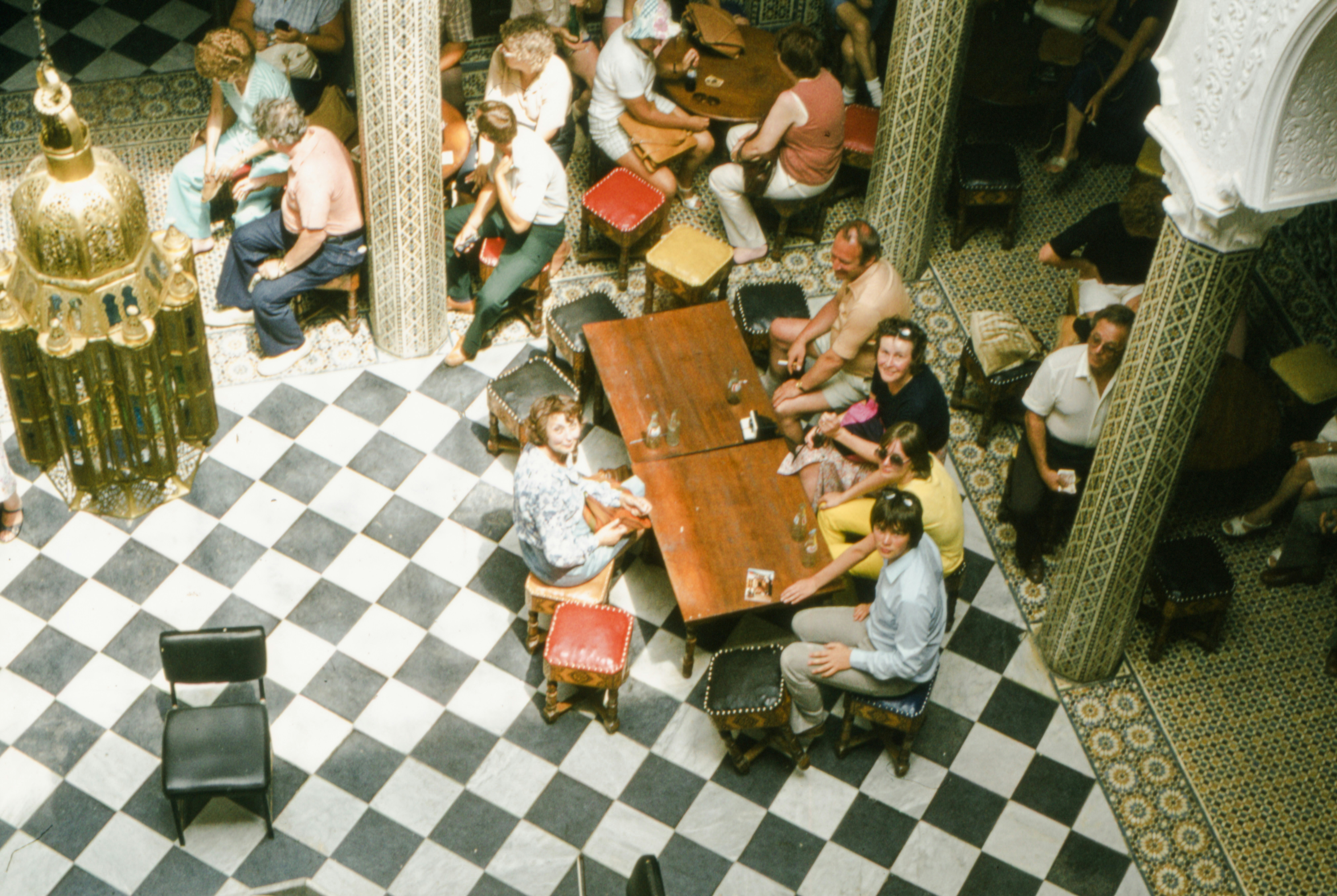 a group of people sitting around a table in a room, 
