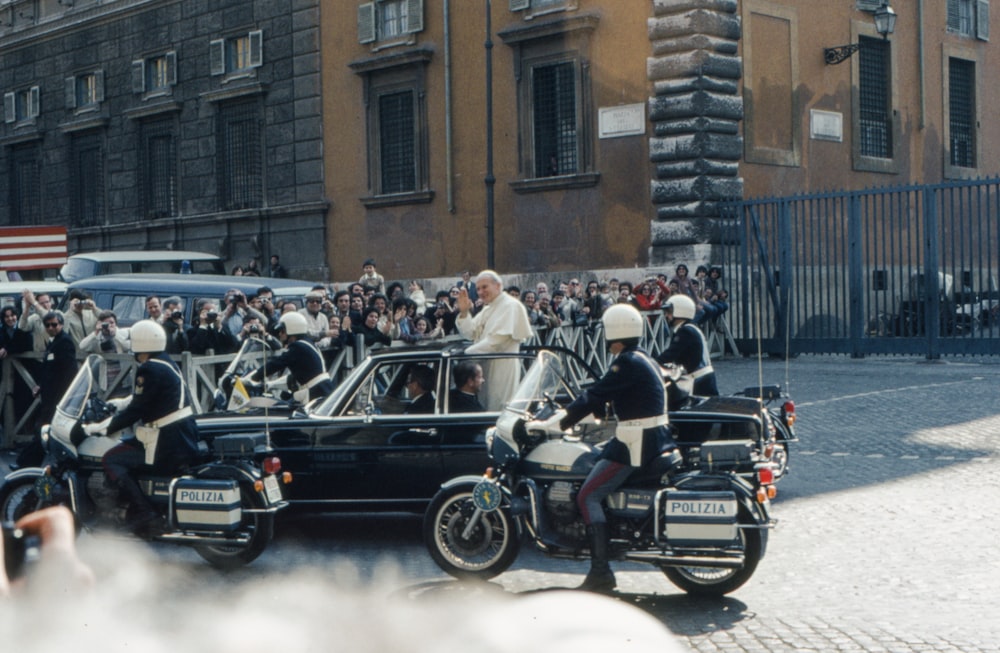 a group of motorcyclists are lined up in front of a car