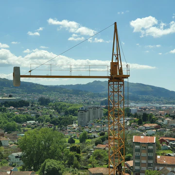 A dramatic full-screen video still of a construction crane moving smoothly over a cityscape.