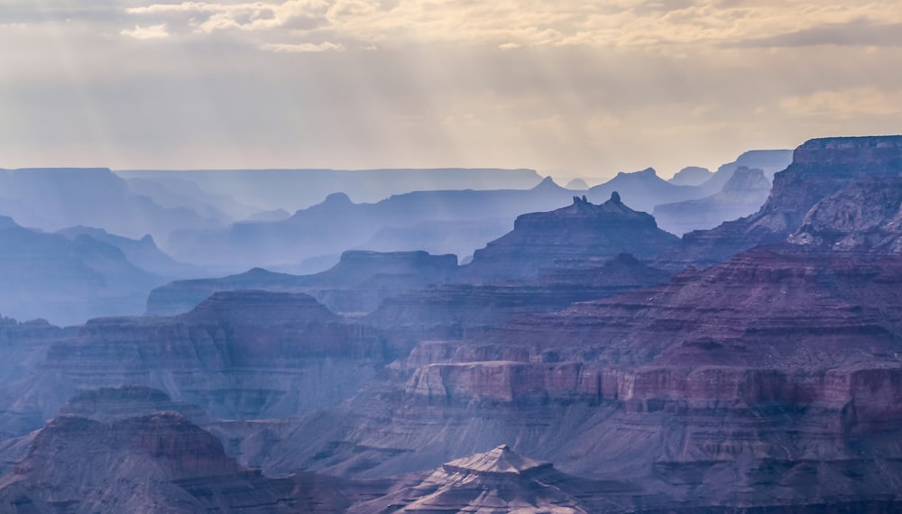 the sun shines through the clouds over the canyon