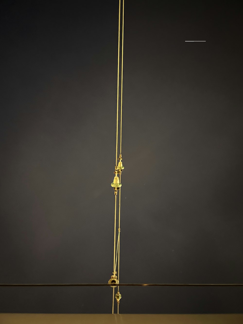 a tall gold pole with two bells hanging from it