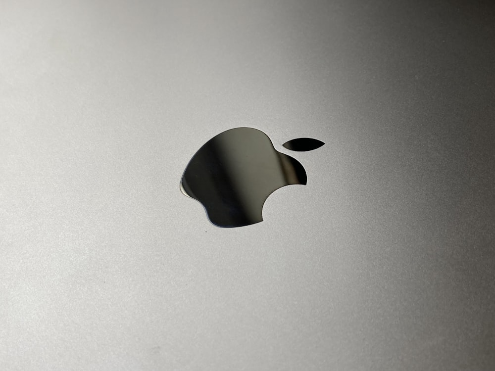 Un primer plano de un logotipo de Apple sobre una superficie plateada