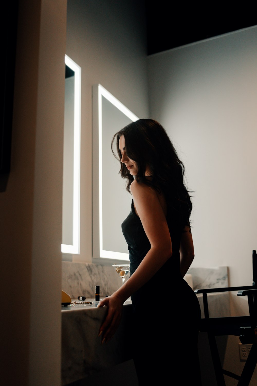 a woman standing in front of a mirror in a bathroom