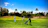 A group of business professionals enjoying a sunny golf event on a lush, green course.