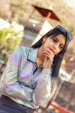 a woman in a silver jacket and sunglasses posing for a picture