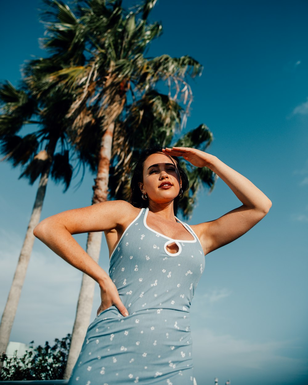 a woman standing in front of a palm tree