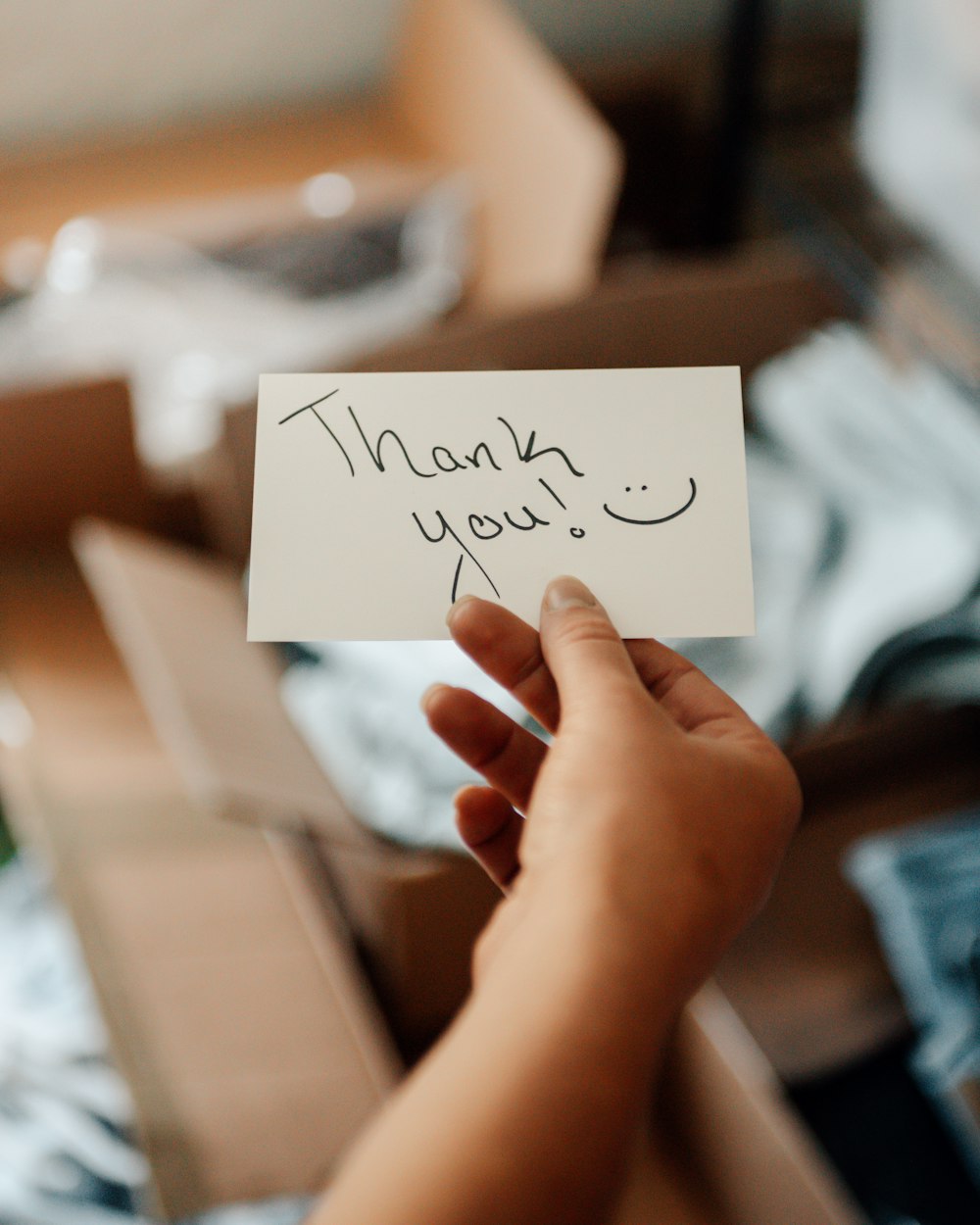 a hand holding a note that says thank you