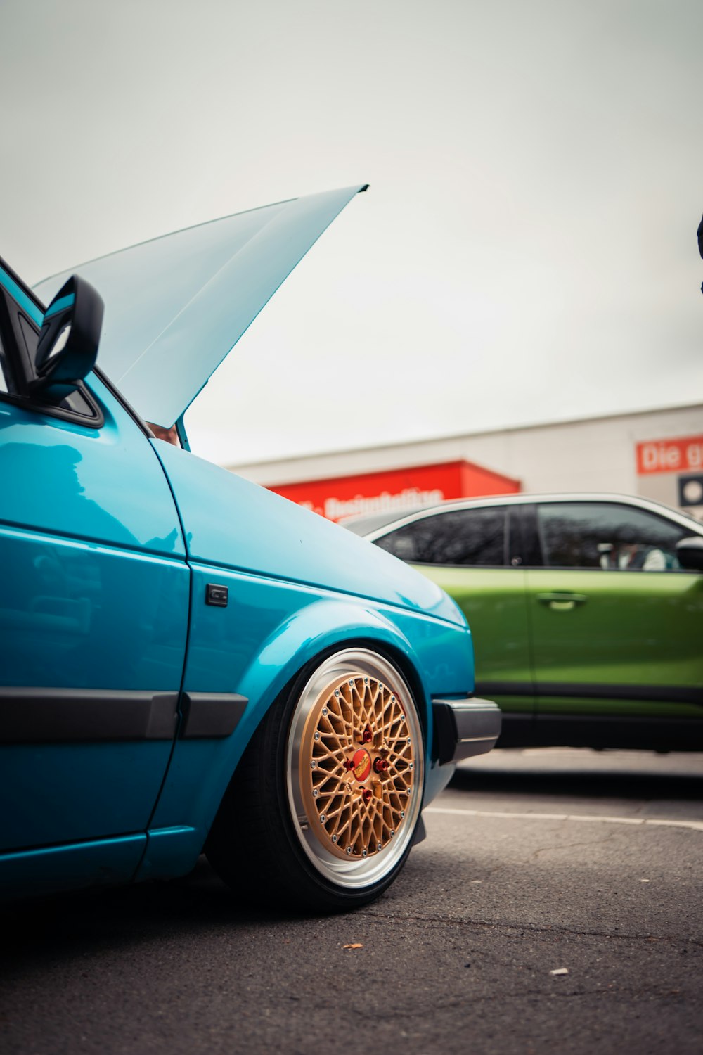 a blue car parked next to a green car