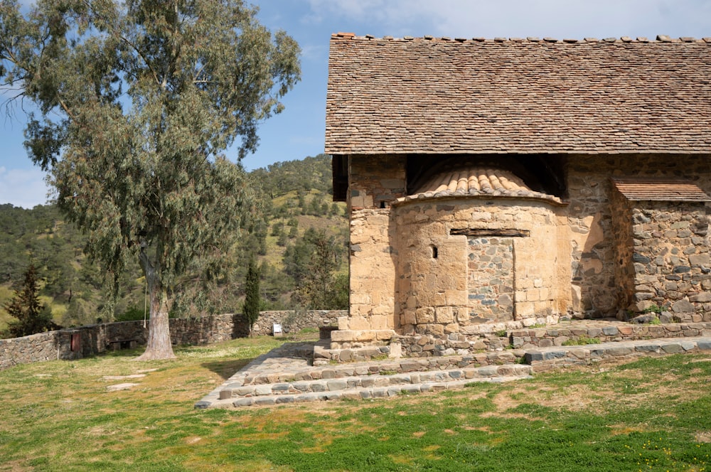 a stone building with a tree in the background