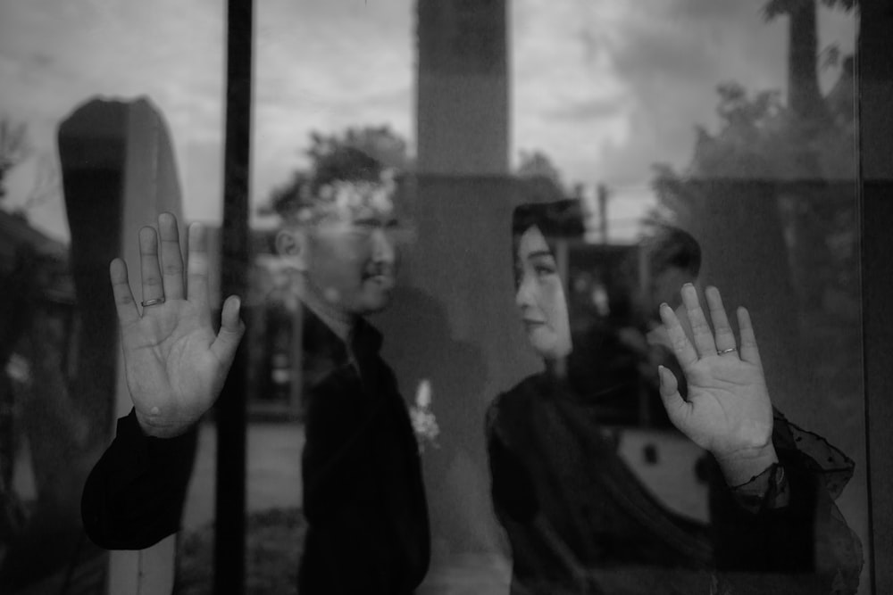 a couple of people that are standing in front of a window