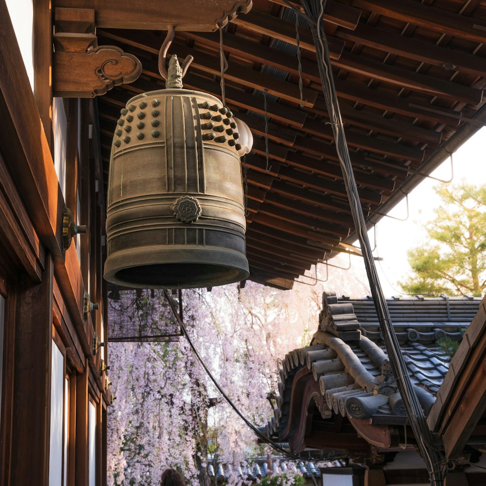 a bell hanging from a roof next to a building