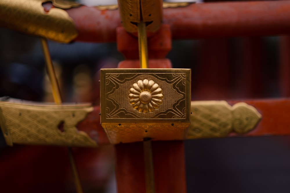 um close up de uma fechadura dourada em um portão vermelho