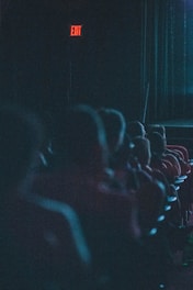 a group of people sitting in a dark auditorium