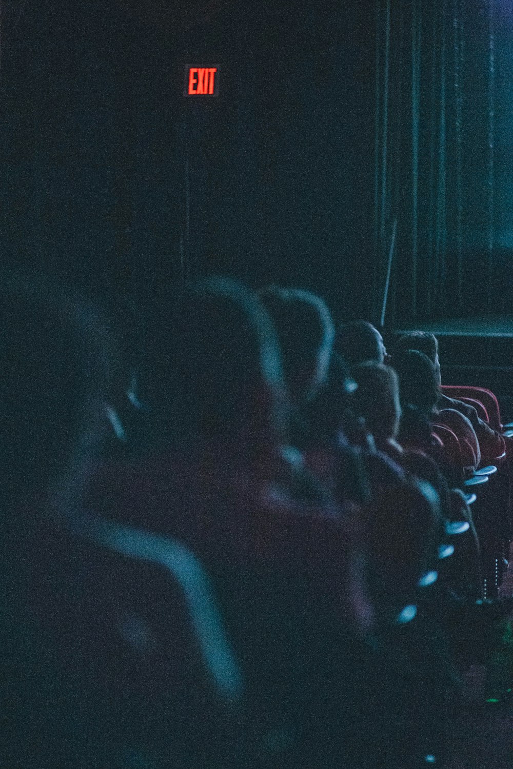 a group of people sitting in a dark auditorium