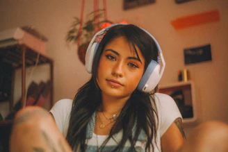 A person calmly listening to audio with headphones in a cozy home setting.