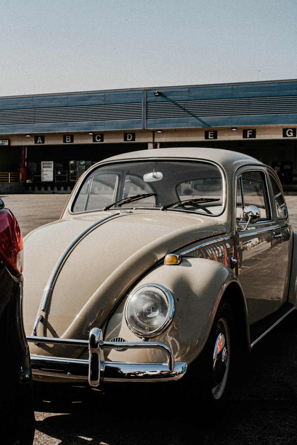 an old vw bug parked in a parking lot