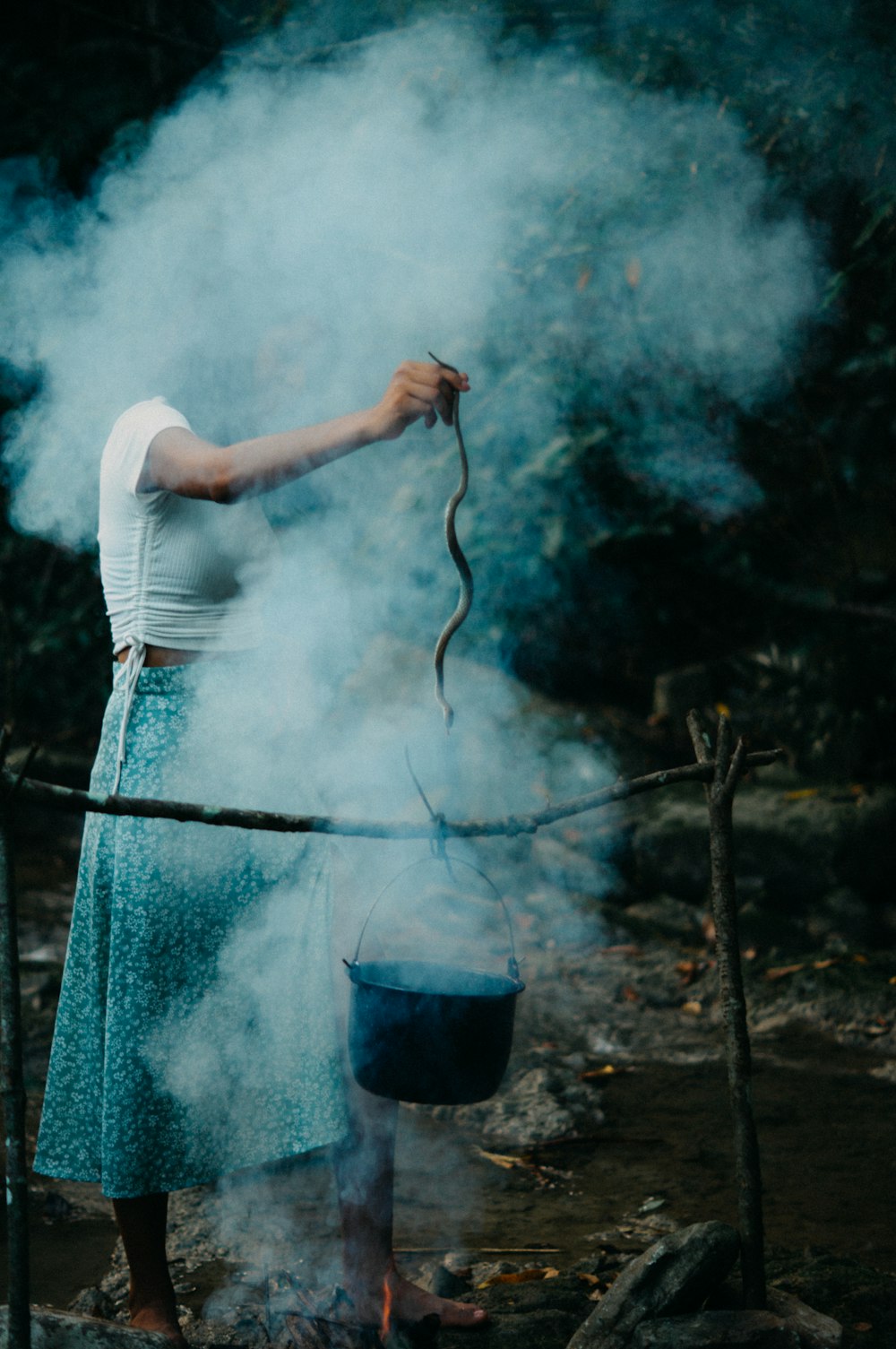 a woman is cooking something on a stick