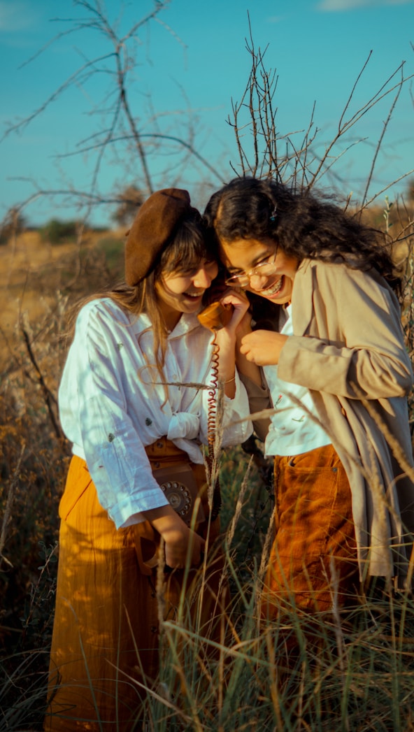two women standing in a field of tall grass