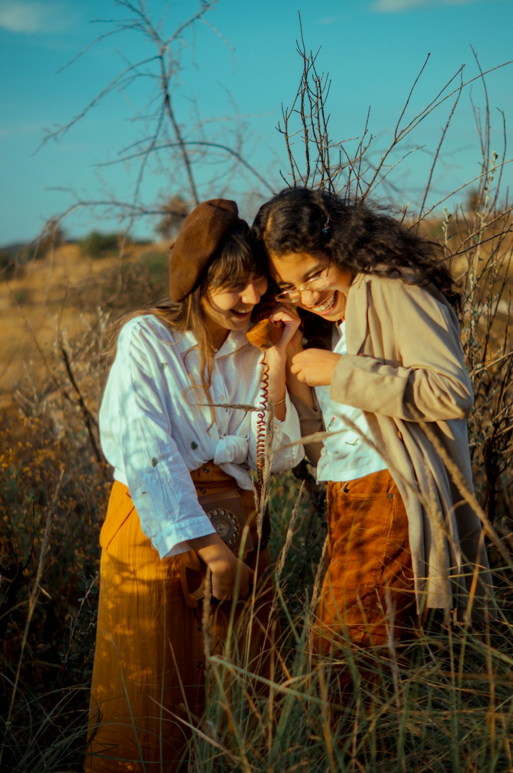 two women standing in a field of tall grass