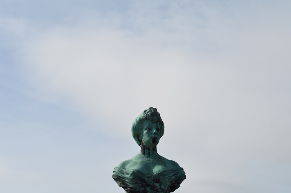 a statue of a woman with a bird on her head