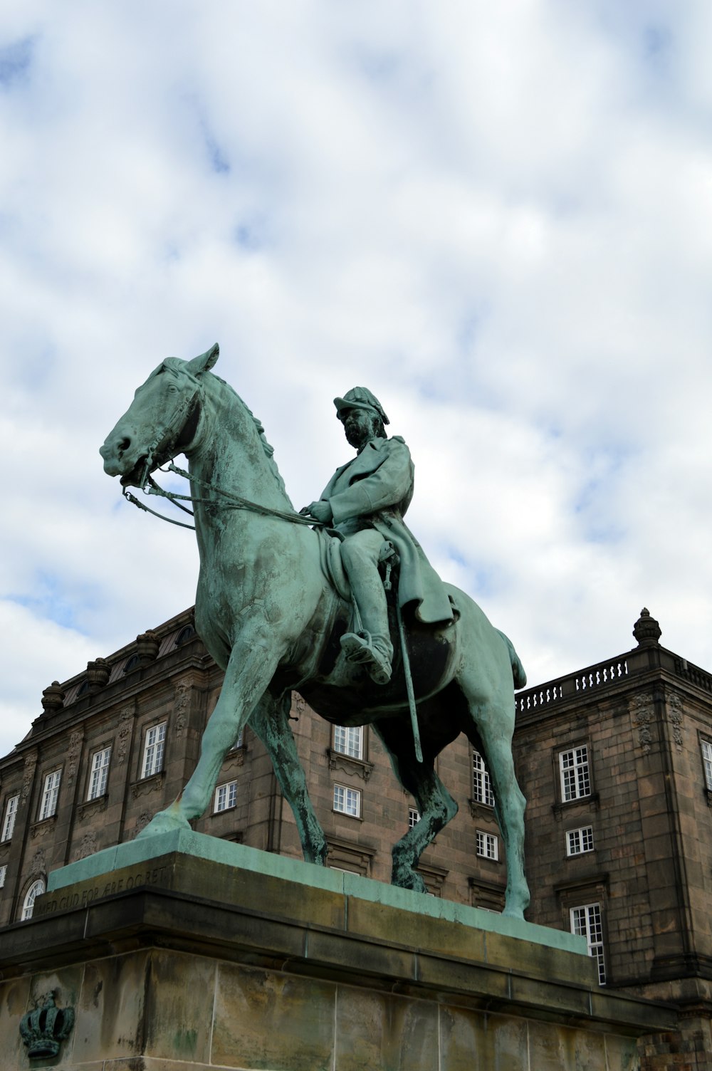una statua di un uomo su un cavallo di fronte a un edificio