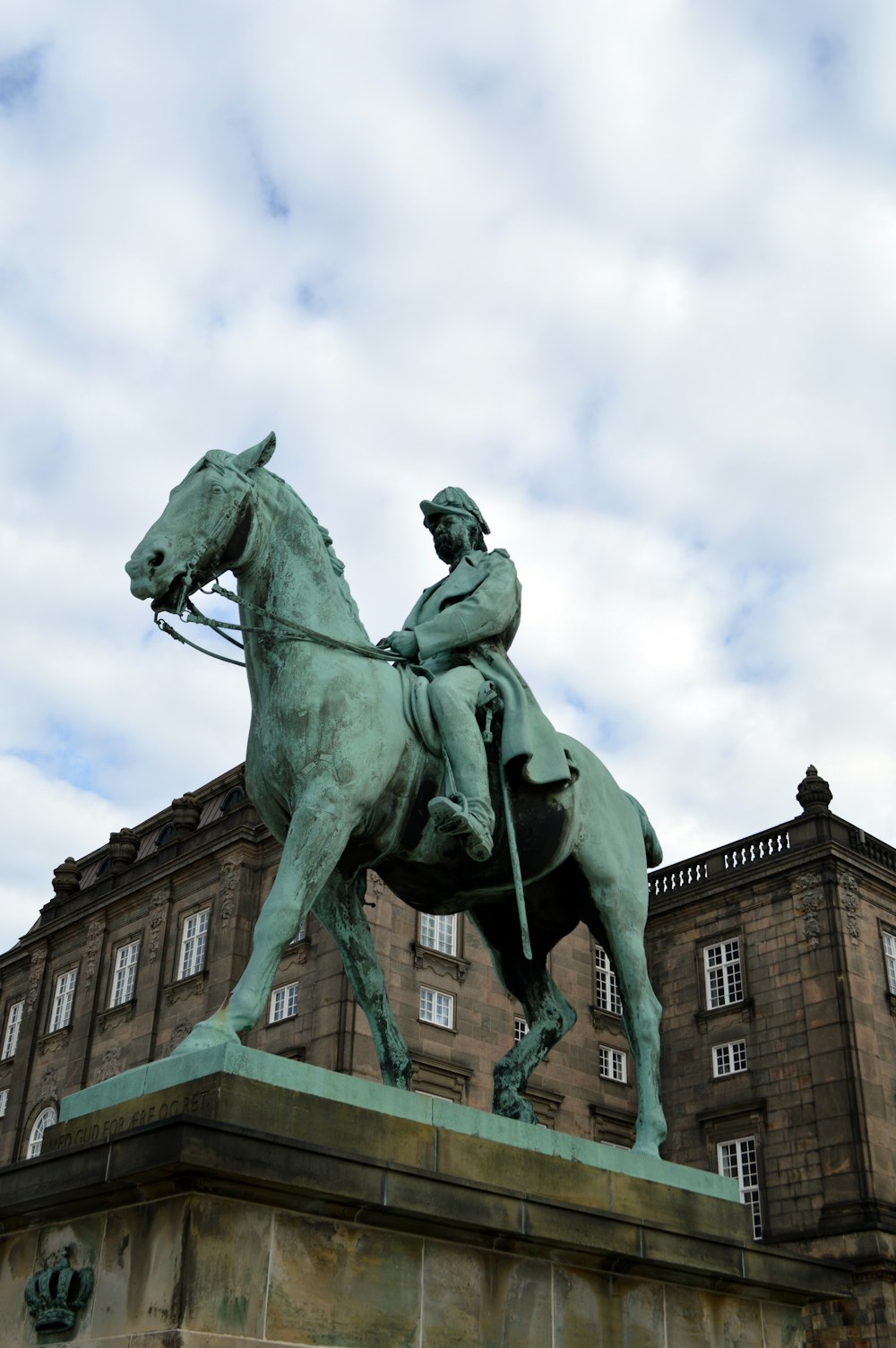 a statue of a man on a horse in front of a building