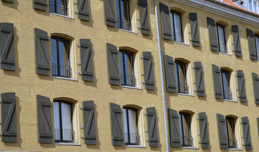 a tall building with many windows and shutters