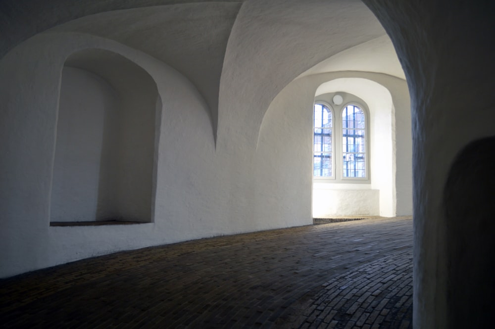 una habitación con ventanas arqueadas y un piso de ladrillo