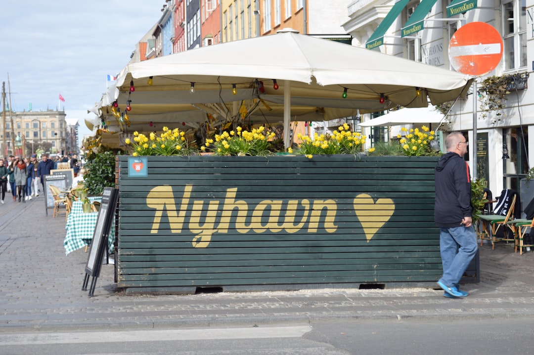 a man standing in front of a sign that says nyhan, Nyhavn