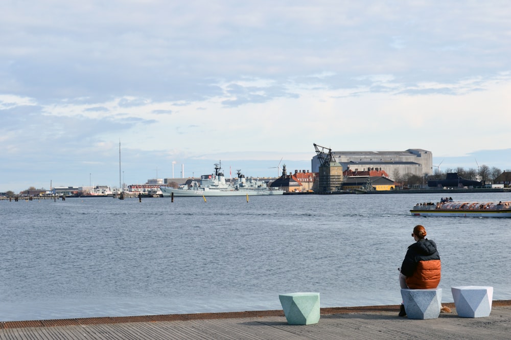 a person sitting on a bench near a body of water