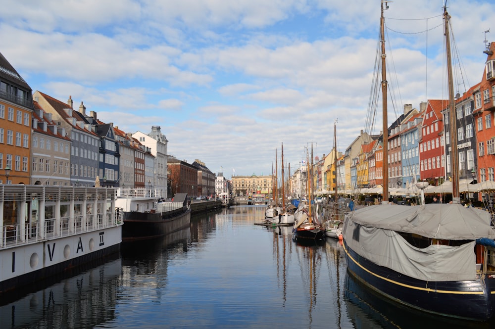 Mehrere Boote liegen neben einer Gebäudezeile im Wasser