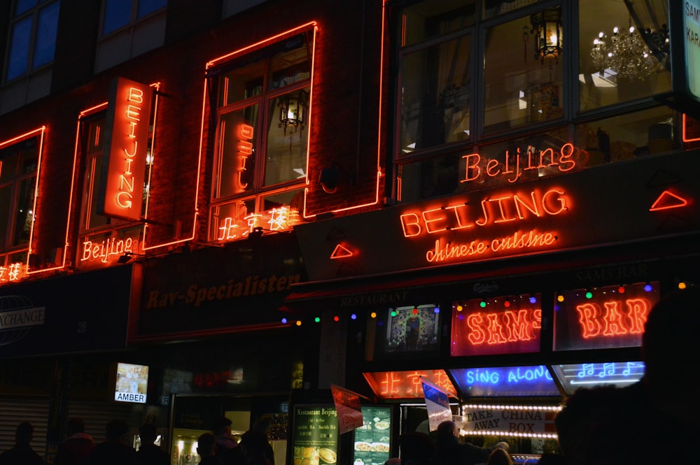 a group of people standing outside of a building at night