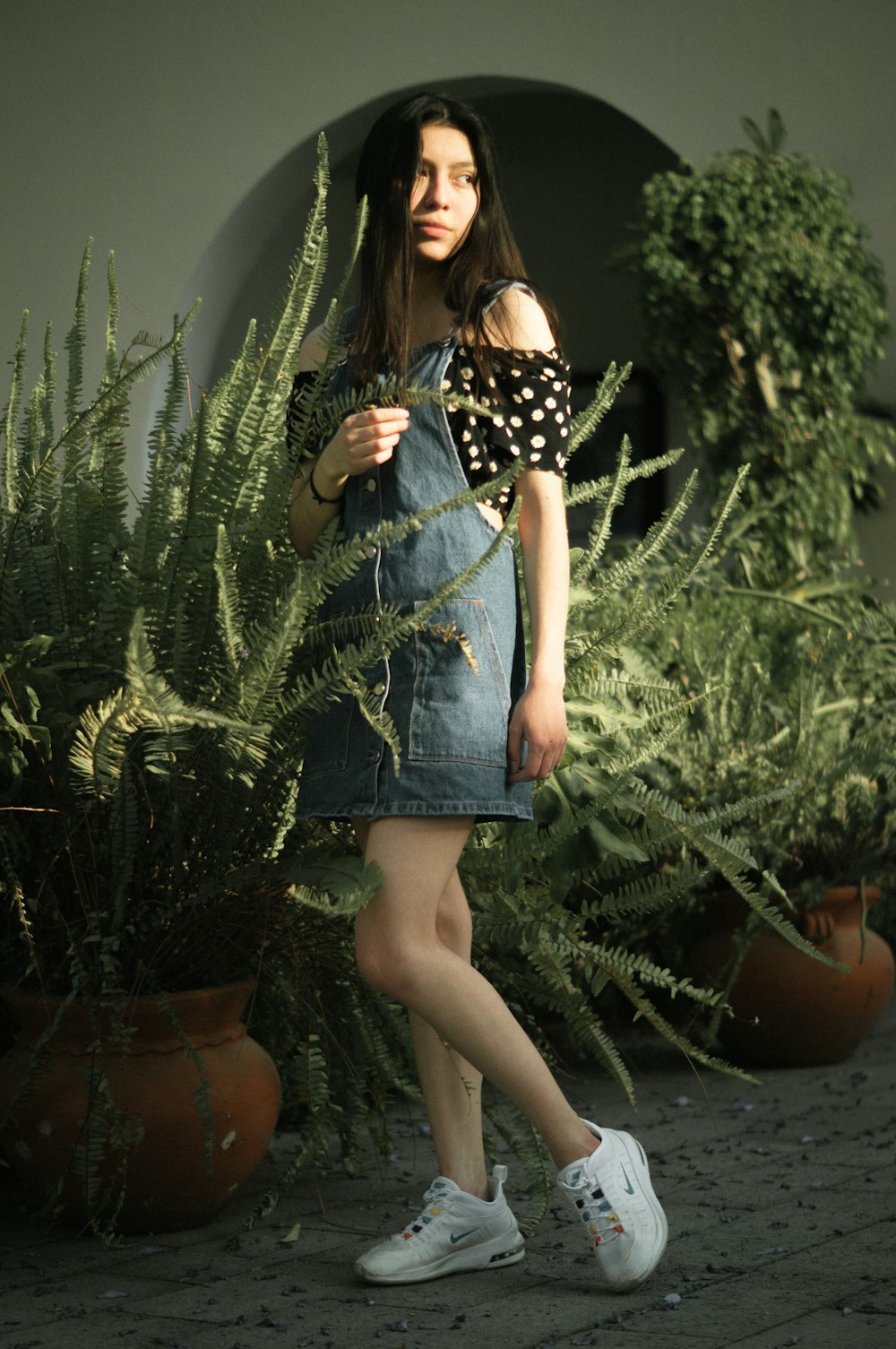 a woman in a polka dot shirt and denim skirt