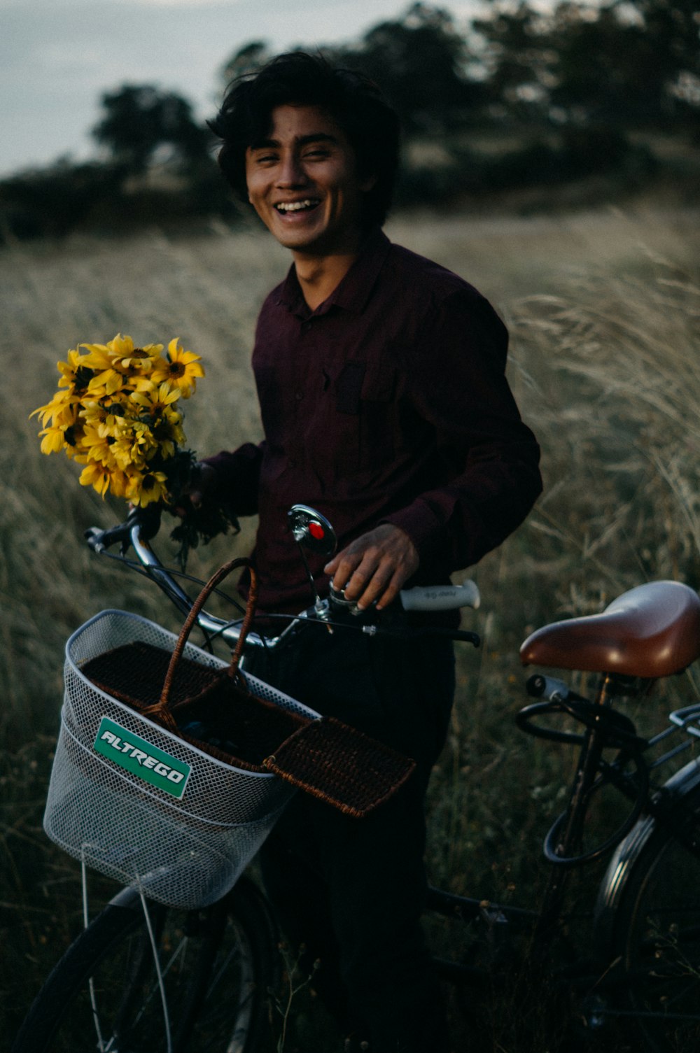 a man standing next to a bike holding a basket of flowers