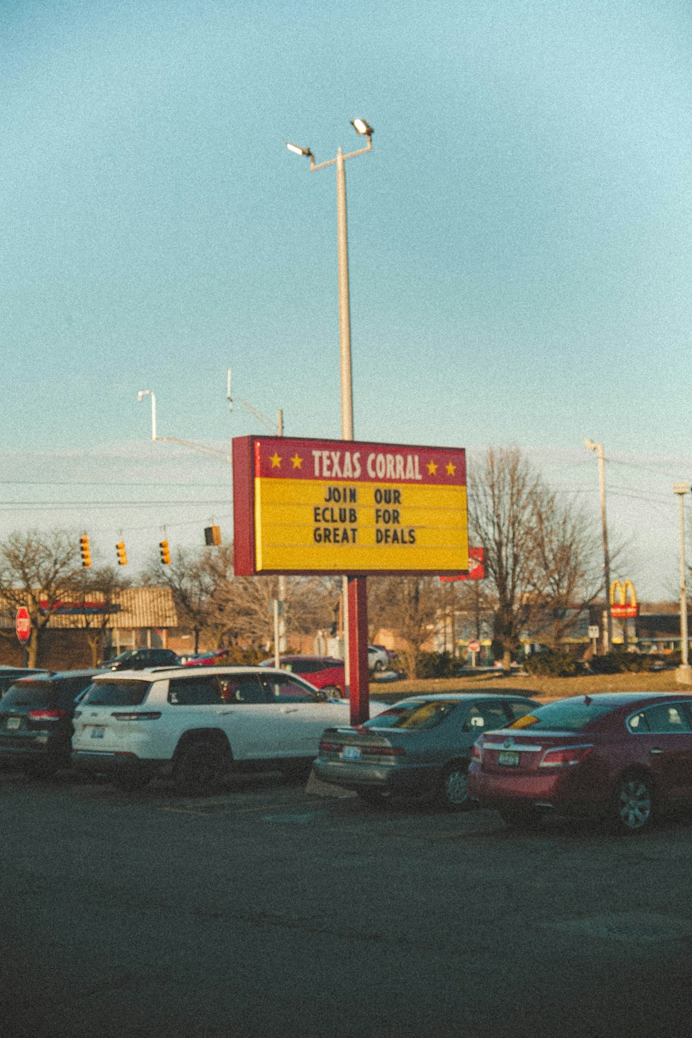 a large sign advertising a business near a parking lot