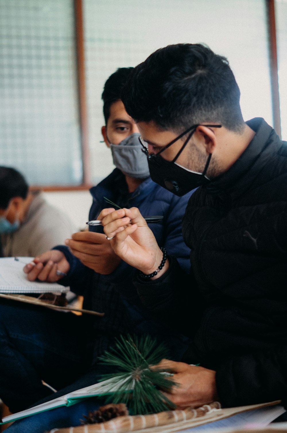 a man wearing a face mask while looking at his cell phone