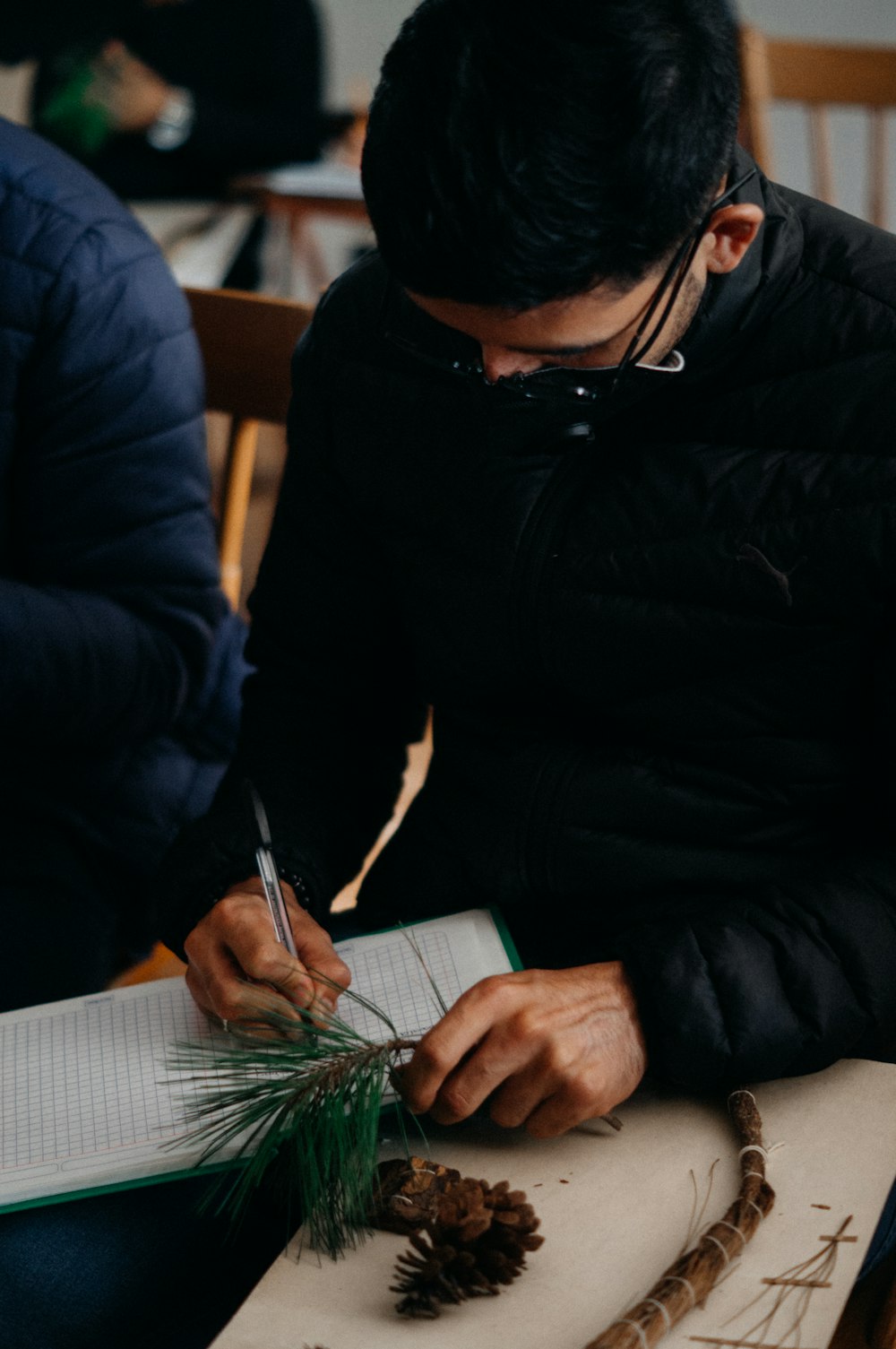 a man sitting at a table working on a piece of paper