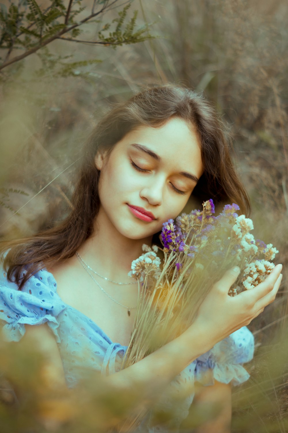 a woman holding a bunch of flowers in her hands