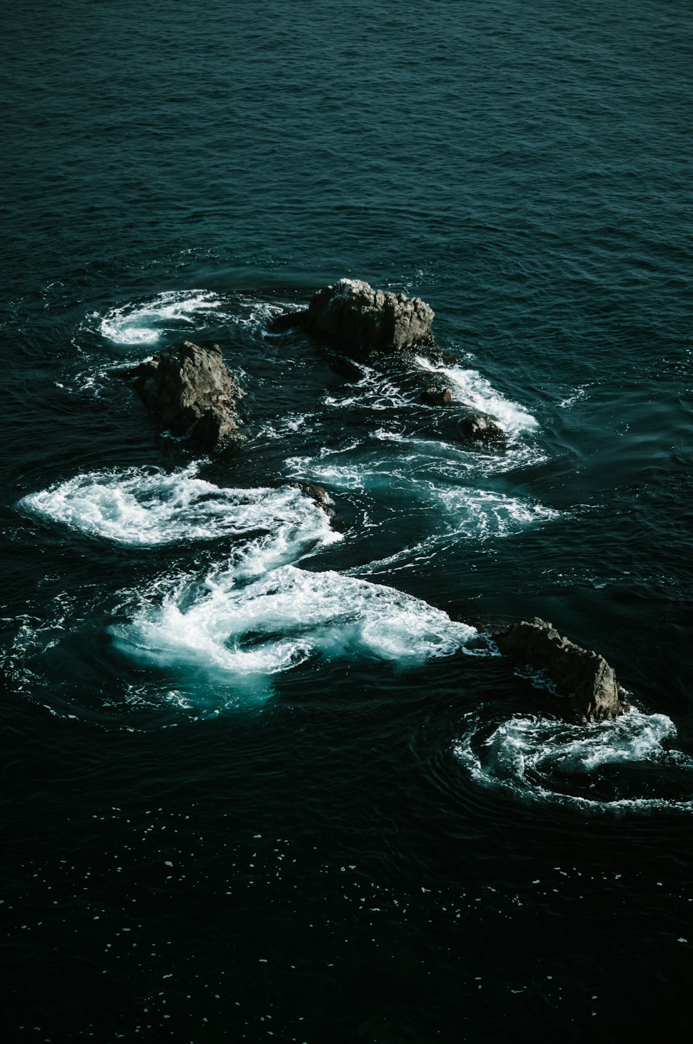 a group of rocks in the middle of a body of water