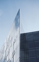 a tall glass building with a sky background