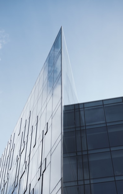 a tall glass building with a sky background