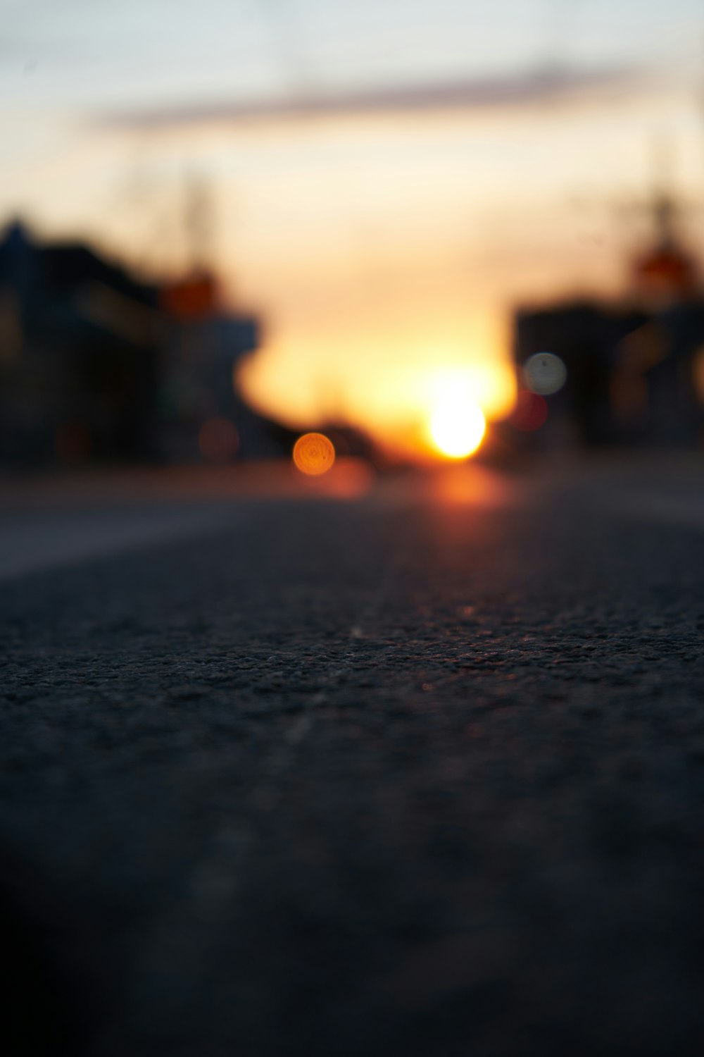 a blurry photo of the sun setting over a street