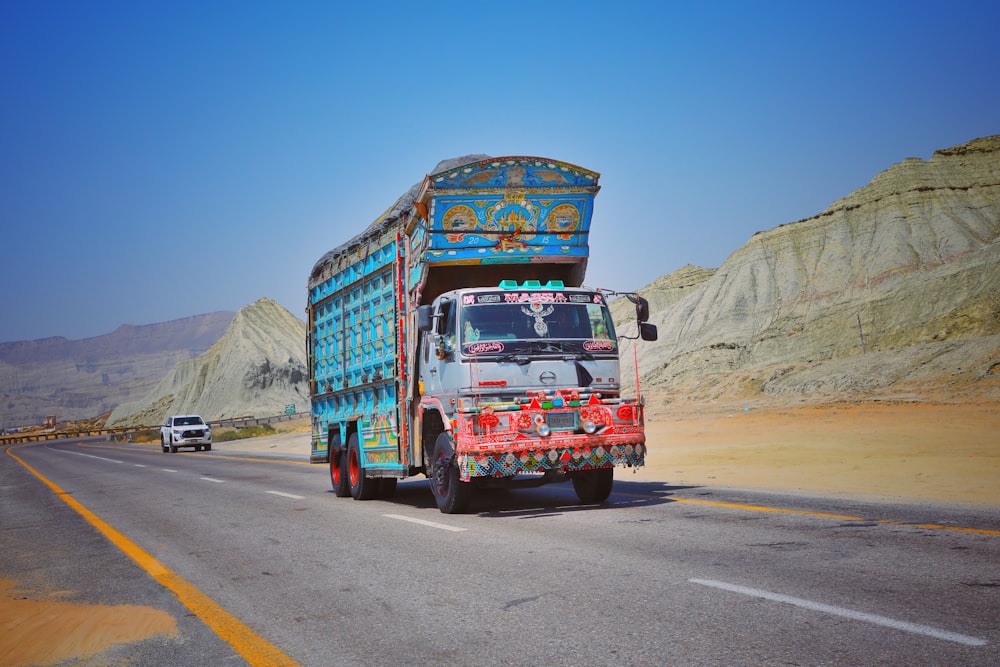 a colorful truck driving down the road in the desert