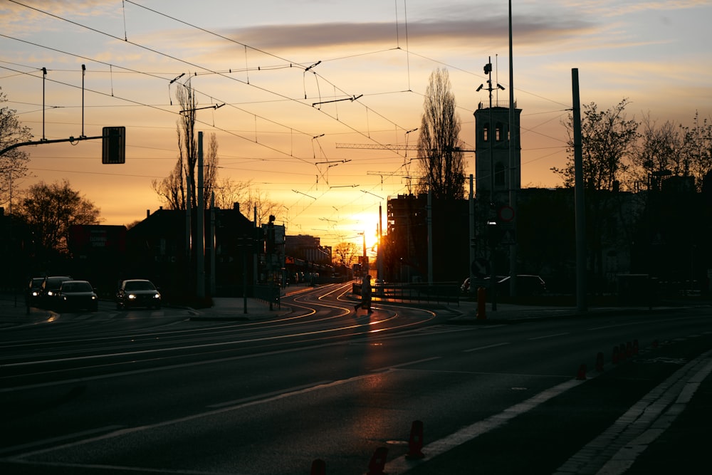 the sun is setting over a city street